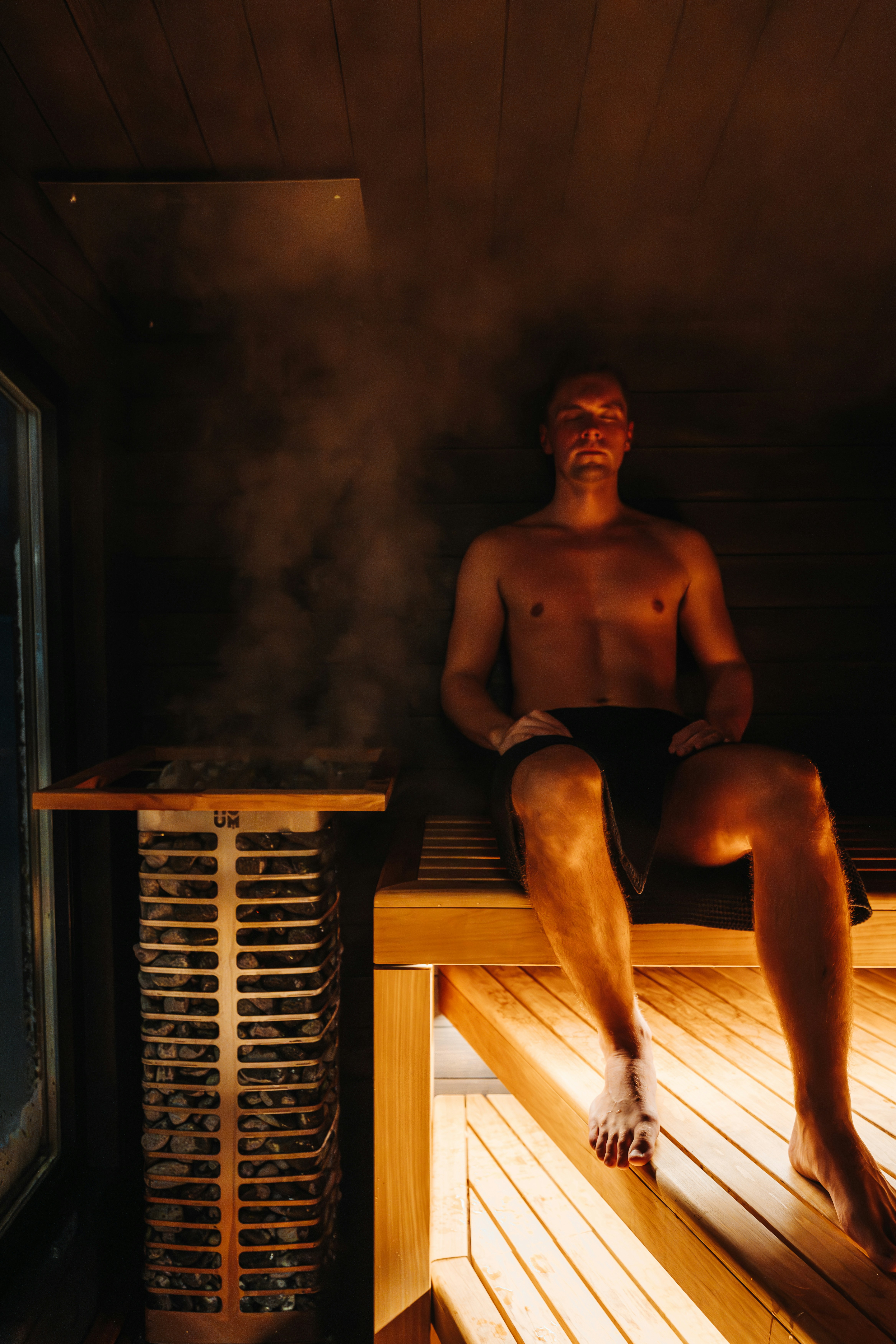 Man in sauna with amber light and steam