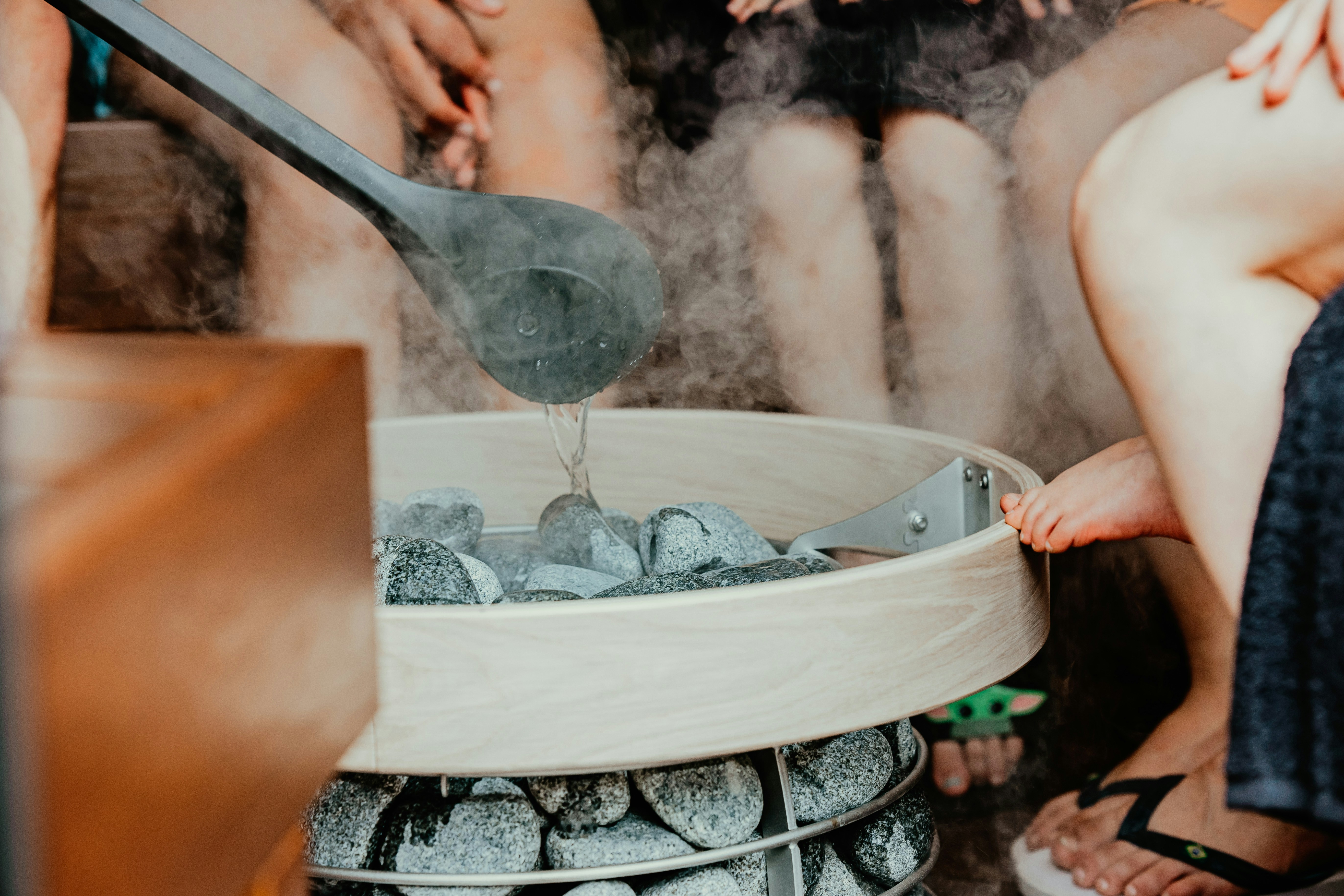 Ladle pouring water on sauna stones
