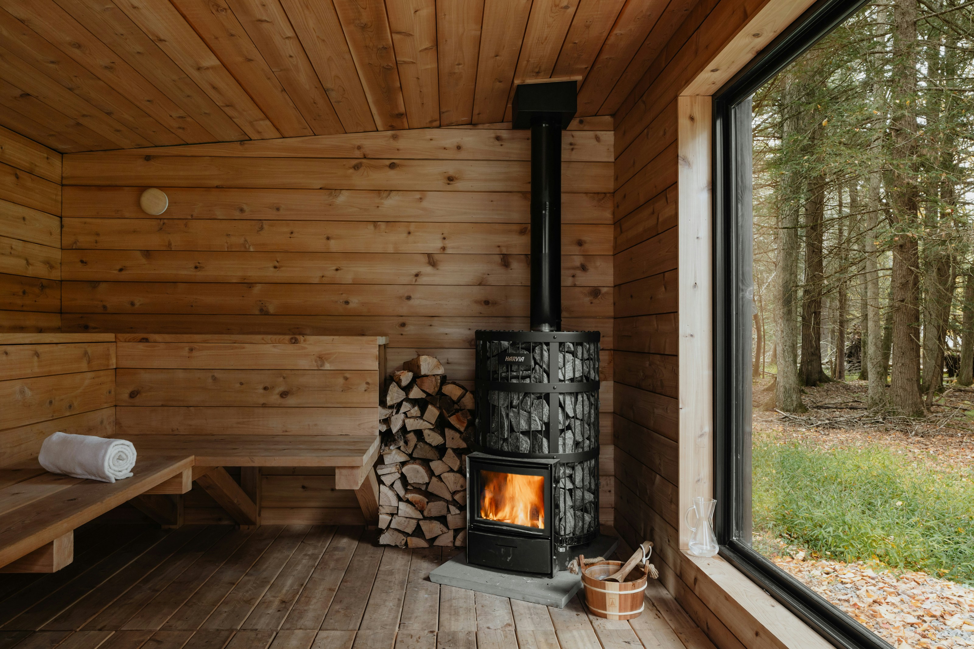 Traditional sauna interior with wood stove and panoramic window